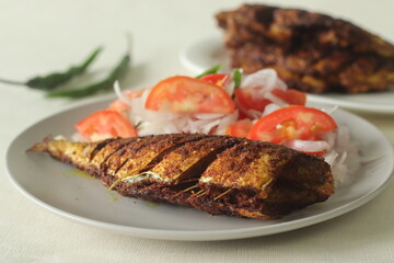 Ayala Meen fry or Mackerel fish fry. Spicy fish fry prepared in South Indian style. Mackerel fish marinated in an oil marinade and shallow fried in oil, served with onions