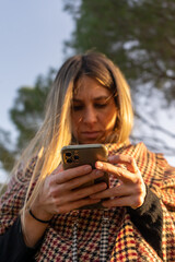 Woman using a mobile phone. Business and communication. Woman in the park. Winter day