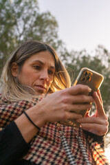 Fototapeta premium Woman using a mobile phone. Business and communication. Woman in the park. Winter day