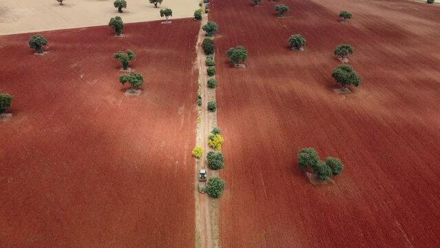 Tractor driving along a road between fields in Castilla La Mancha, Spain.