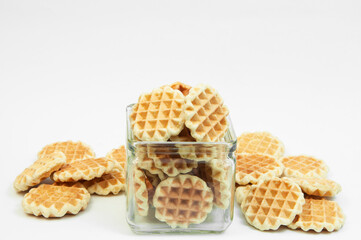 cookies in a glass jar on a white background. Belgian waffles in a bowl. fresh baking concept.