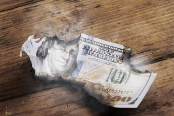Closeup shot of burnt remainings of a one hundred dollar bill damaged in a fire