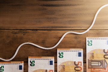 Wavy white rope above several fifty euro banknotes.