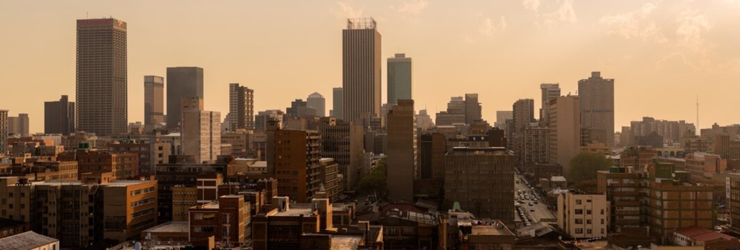 A horizontal panoramic cityscape taken at sunset, of the central business district of the city of Johannesburg, South Africa