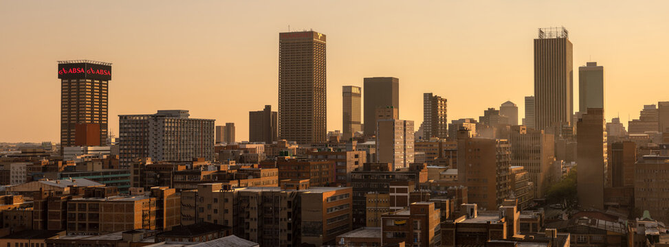 A horizontal panoramic cityscape taken at sunset, of the central business district of the city of Johannesburg, South Africa