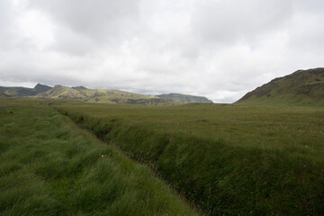 Green Grassy mountain Landscape in the highlands. Travel and nature on a beautiful cold day