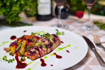 Salmon baked with vegetables in berry sauce.