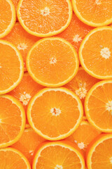 Slices of oranges as a background, top view.