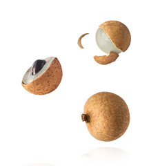 Fresh raw longan fruit falling in the air isolated on white