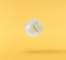 Fresh raw longan fruit falling in the air isolated on yellow background.