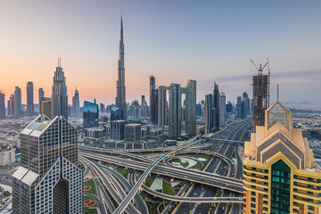 Fototapeta na wymiar Skyline in Dubai Downtown at sunrise. High rise buildings with major intersection of sheik zayed road. Tallest building in the city of Dubai Burj Khalifa with skyscapers