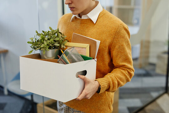 Cropped Shot Of Young Man Carrying Box Of Personal Belongings Starting New Job In Office, Copy Space