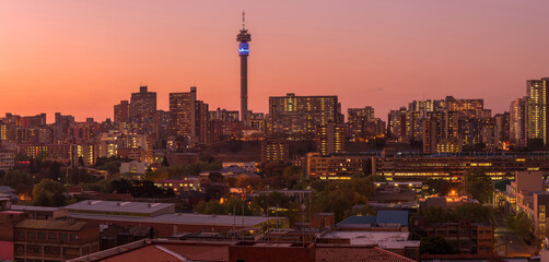 A horizontal panoramic cityscape taken after sunset, of the central business district of the city of Johannesburg, South Africa