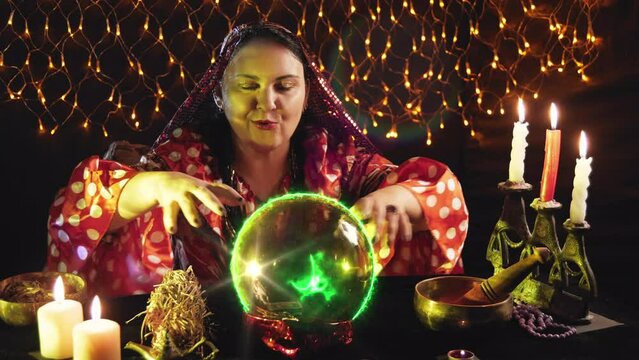 A young brunette fortune teller reads the future from a crystal ball. Overall plan