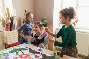 Group of little kids working on project during creative art and craft class at school.
