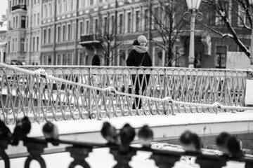 Woman standing on a bridge over Griboyedov Canal, St. Petersburg, Russia. Black and white photo.