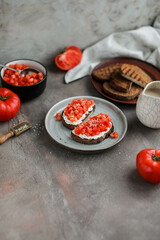 Simple sandwiches with cottage cheese, fresh tomatoes and hemp seeds. Healthy snacks with raw vegetables
Two toasts on a gray plate