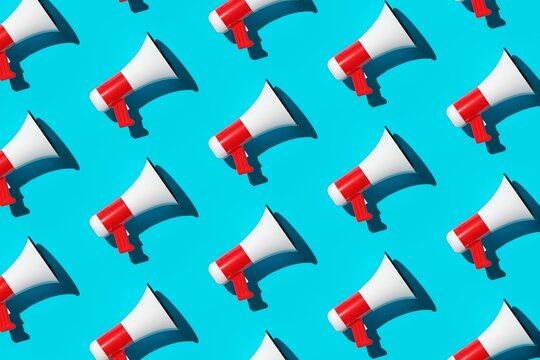 Diagonal array pattern of white and red megaphones or bullhorns over cyan blue background, business announcement or communication concept, flat lay top view from above