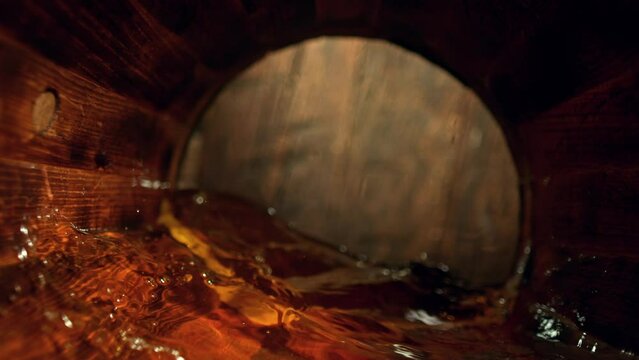 Super Slow Motion Detail Shot of Waving Whiskey in Wooden Barrel at 1000fps.