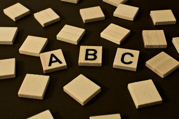 Obraz premium Scattered wooden squares. in the middle the word abc symbolizing for example education, letters or the alphabet