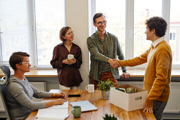 Group of smiling people welcoming new employee in office, career and recruitment concept, copy space
