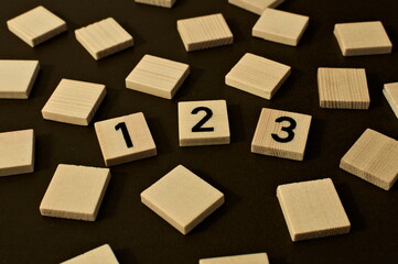 Obraz premium Scattered wooden squares. in the middle write 123 symbolizing e.g. education, numbers or mathematics
