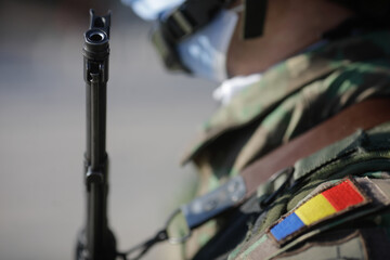 Details with Romanian soldiers holding AK 47 automatic rifles during a public ceremony.