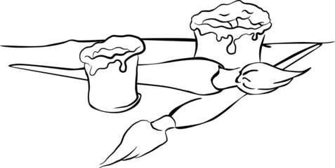 Two paint brushes are lying on the table in the painting studio. Next to it are the paint containers.
