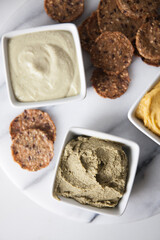 Top view of variety of dips and crackers