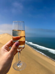 Woman with glass of champagne. Sandwich Harbour in Namibia.