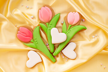 background banner greeting card for valentine's day with bouquet of pink tulips and heart gingerbread cookies on silk fabric background