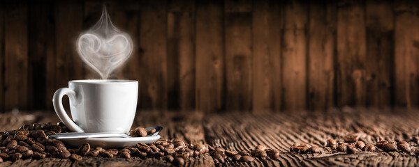 White Espresso Cup And Saucer With Heart Shaped Steam On Wooden Table