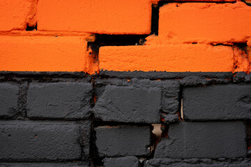 Orange and black brick wall texture background. Damaged, old building with holes. Lines on house...
