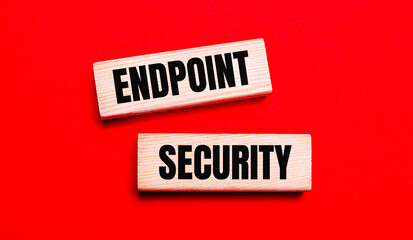 On a bright red background, there are two light wooden blocks with the text ENDPOINT SECURITY