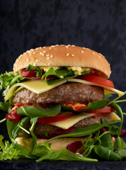 Double cheeseburger with rucola, tomatoes and sauces