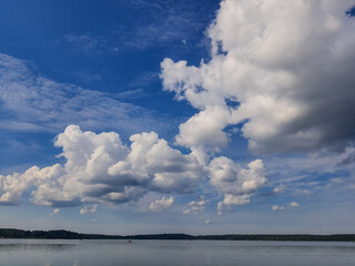 Obraz premium Misty seascape - calm water surface of the lake reflects sky. Altocumulus clouds are full of streaks of beautiful usually appear between lower stratus clouds and higher cirrus clouds