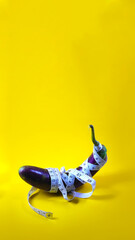 Close-up view of Purple eggplant with copy space wrapped by white measuring tape isolated on a...