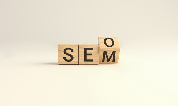 SEO vs SEM. Wooden cube block flip over word SEO to SEM on Yellow studio background.