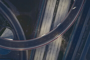 Top down perspective of curved road, road flyover aerial view. Transport industry toned image
