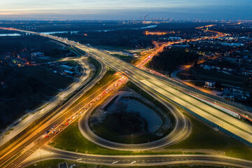 Illuminated road junction at dusk aerial view