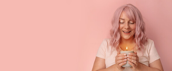 Portrait of pretty young Caucasian woman holds a burning candle in his hands. Valentine, romance