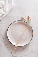 Eco mock up. Ears on an empty plate and cloth on a light concrete background. Top and vertical view.