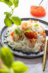 Shirataki noodles, shrimps and caviar. Healthy low carbs, low calories lunch on a light background