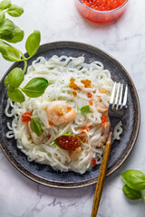 Shirataki noodles, shrimps and caviar. Healthy low carbs, low calories lunch on a light background