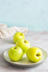 Fresh green apples on a plate on the table. Detox diet. Lifestyle. Vertical view
