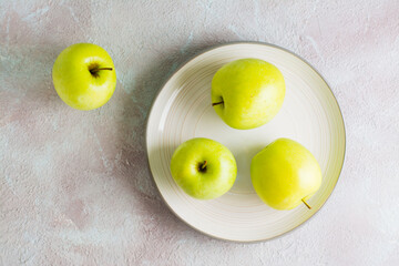 Fresh green apples on a plate on the table. Detox diet. Lifestyle. Top view