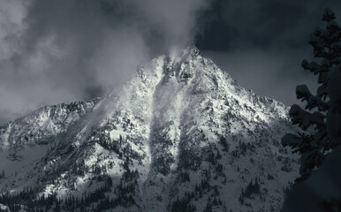 Panorama of dramatic snowy peaks above the clouds in the North Cascades, Washington
