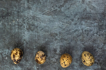 Easter background. Quail eggs at the bottom against a dark background.