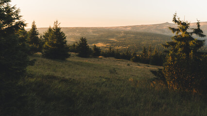 Spring hilly landscape at sunset time. Trees covered in sun and meadows. View of Krkonose, Pancavske vodopady, Czech Republic