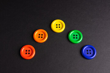 Different colored buttons in a rainbow pattern on a black background